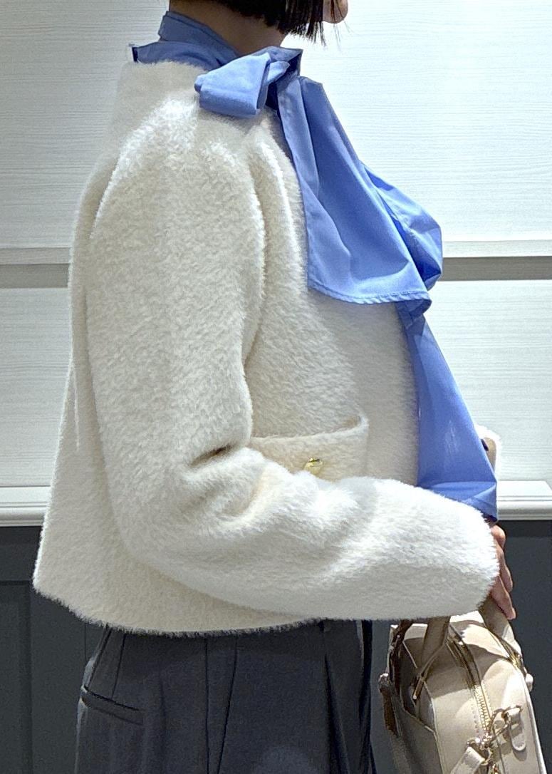 ピンク系のボストンバッグ、グレー系のスラックス、ホワイト系のカーディガン/ボレロを着用したレディースの冬コーディネートの6枚目の写真