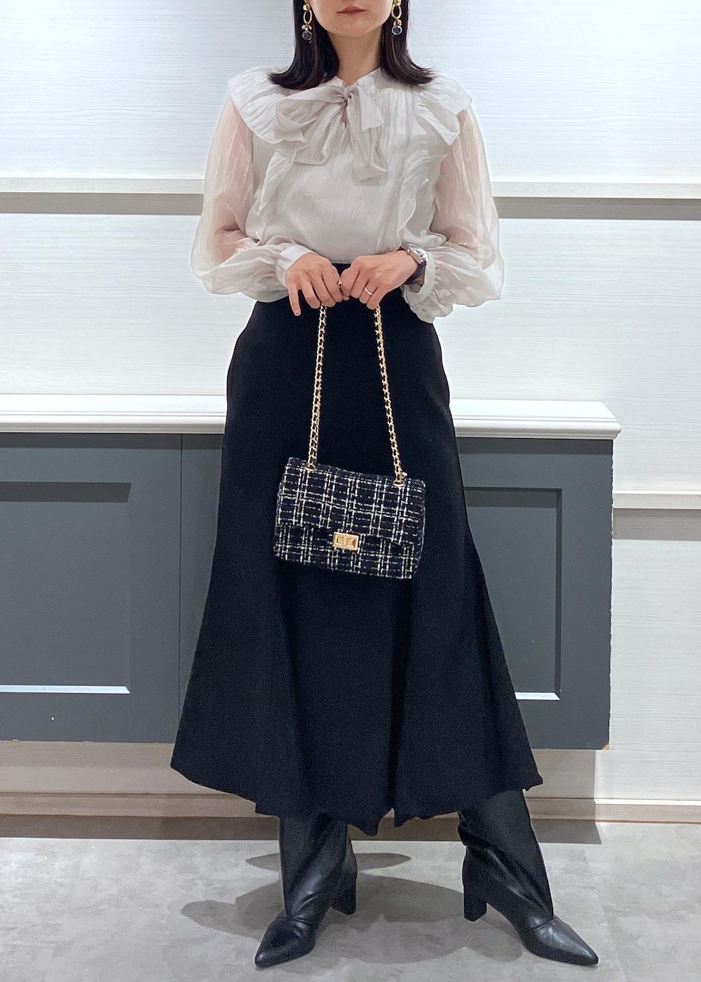 ブラック系のキャミソール、ブラック系のブーツ、ブラック系のショルダーバッグを着用したレディースの秋コーディネートの2枚目の写真