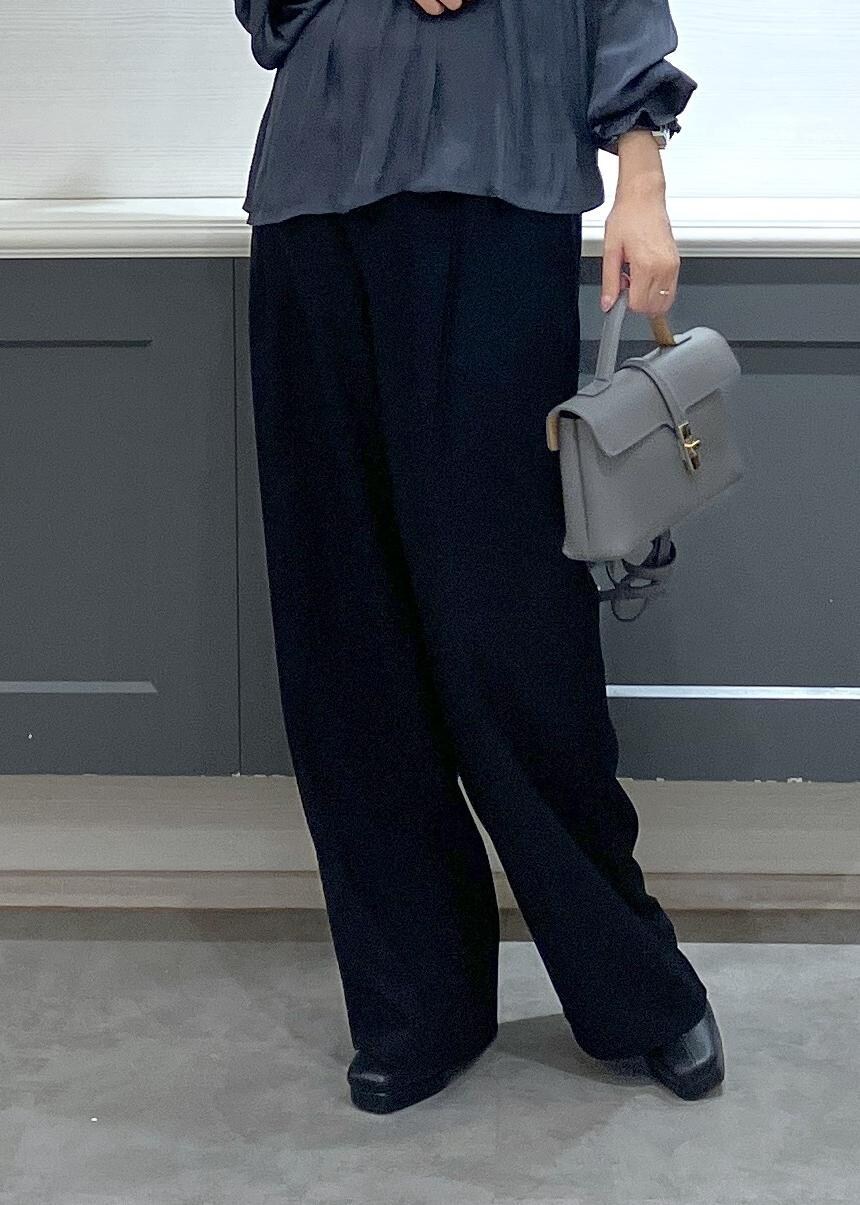 ホワイト系のキャミソール、グレー系のショルダーバッグ、ブラック系のスラックスを着用したレディースの秋コーディネートの9枚目の写真