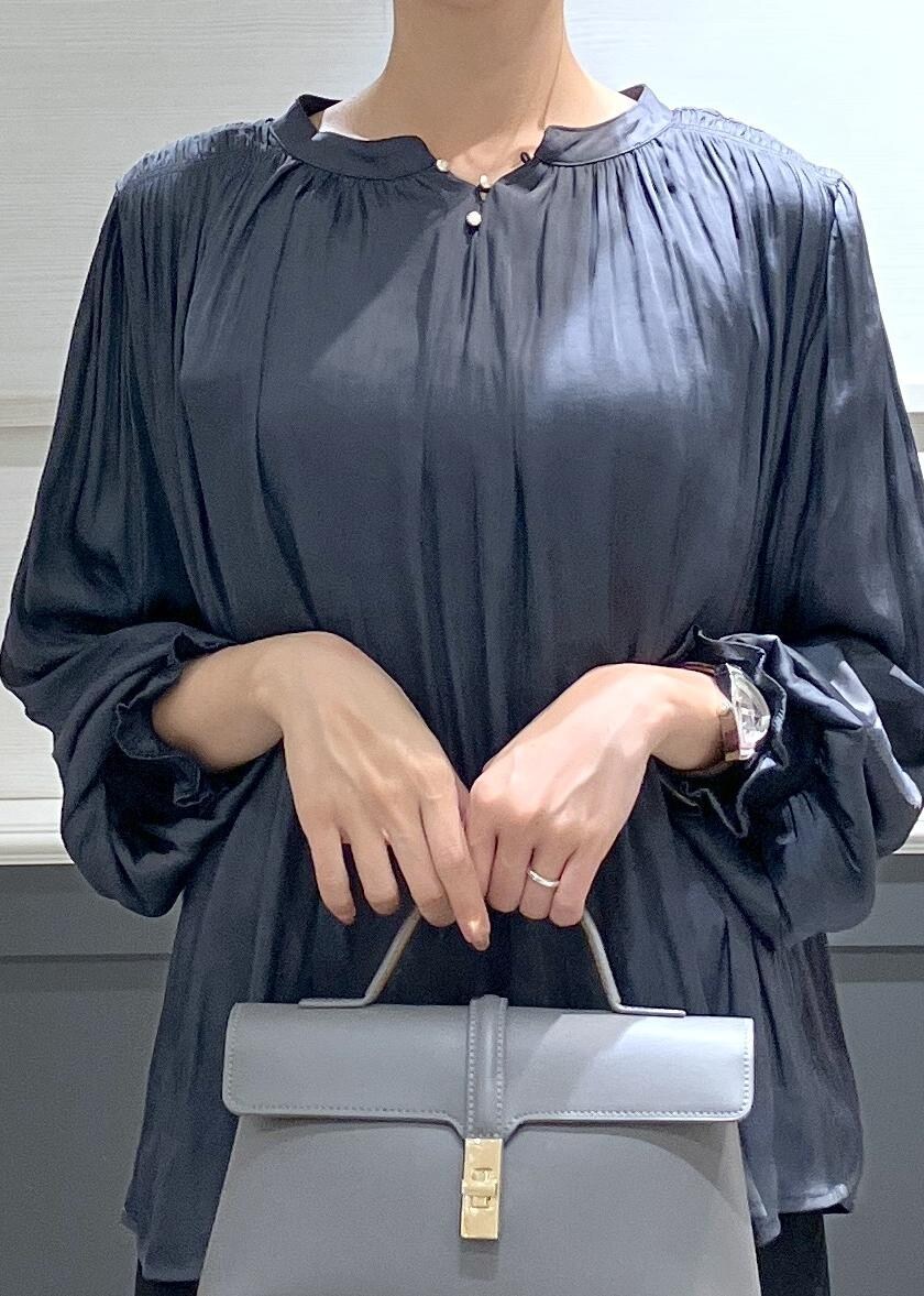 ホワイト系のキャミソール、グレー系のショルダーバッグ、ブラック系のスラックスを着用したレディースの秋コーディネートの5枚目の写真