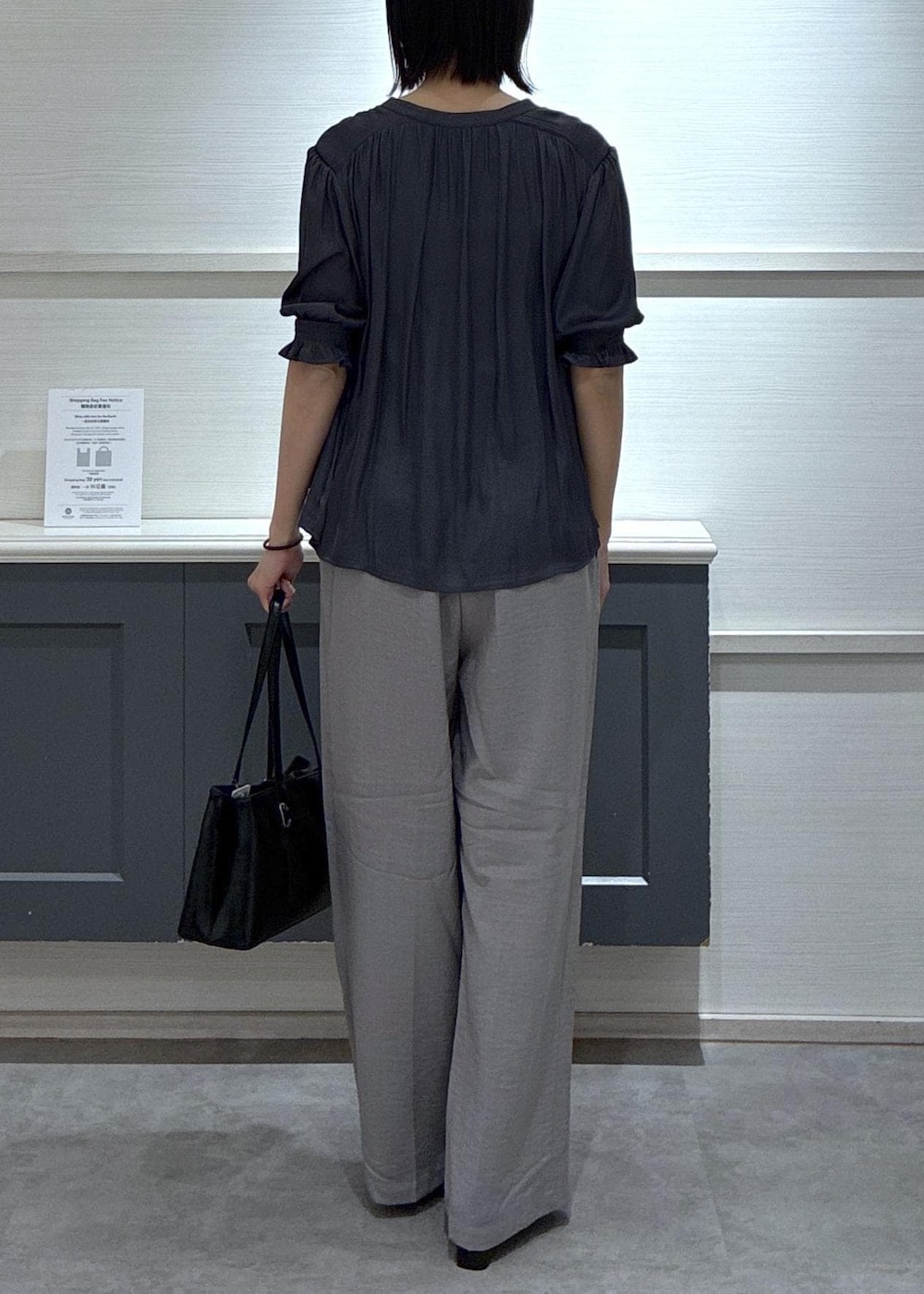 ブラック系のパンプス、ホワイト系のキャミソール、グレー系のその他パンツを着用したレディースの春コーディネートの3枚目の写真