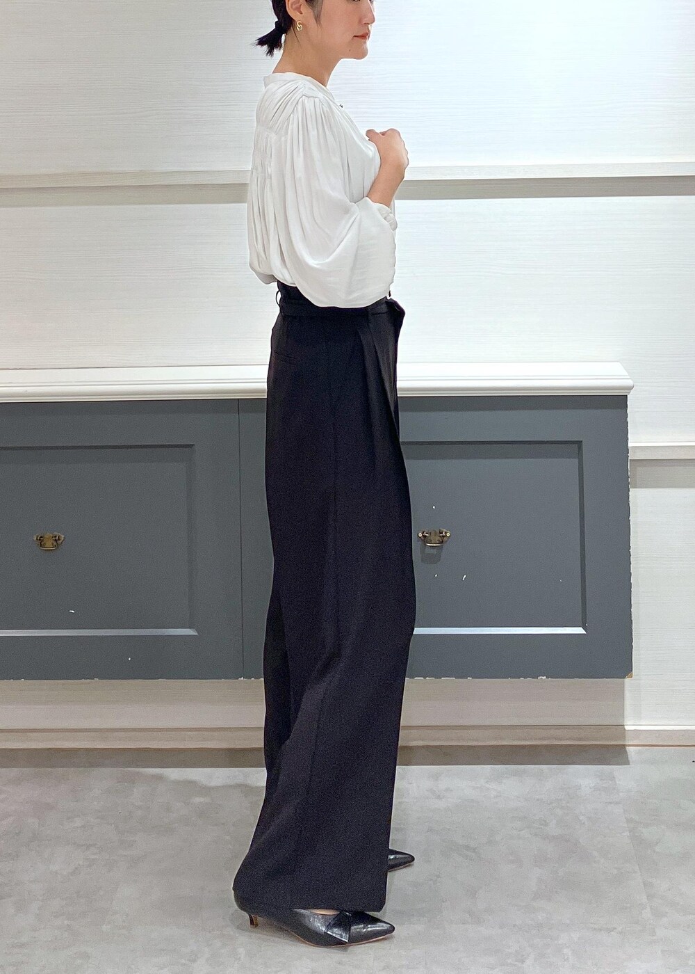 ブラック系のパンプス、ブラック系のショルダーバッグ、ブラック系のスラックスを着用したレディースの夏コーディネートの3枚目の写真