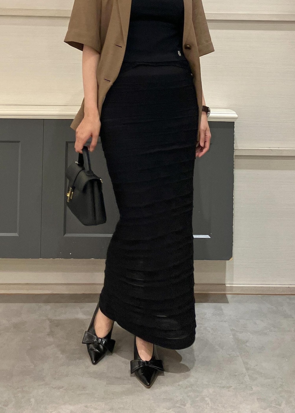 ブラック系のショルダーバッグ、ブラック系のパンプス、ブラック系のキャミソールを着用したレディースの夏コーディネートの3枚目の写真