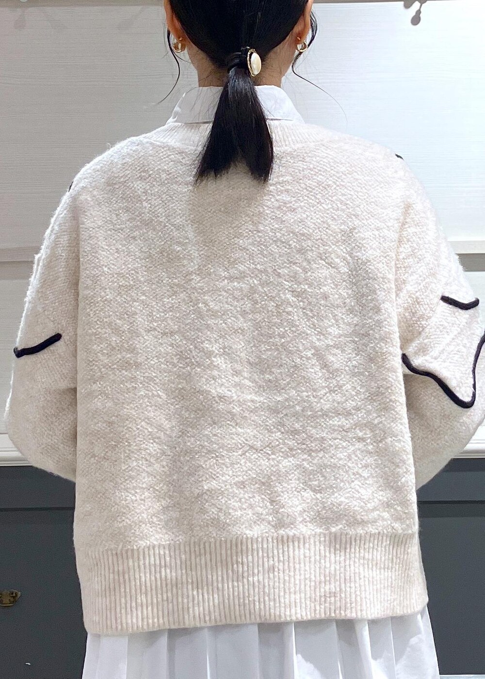 ブラック系のパンプス、ブラック系のスカート、ホワイト系のシャツ/ブラウスを着用したレディースの秋コーディネートの5枚目の写真