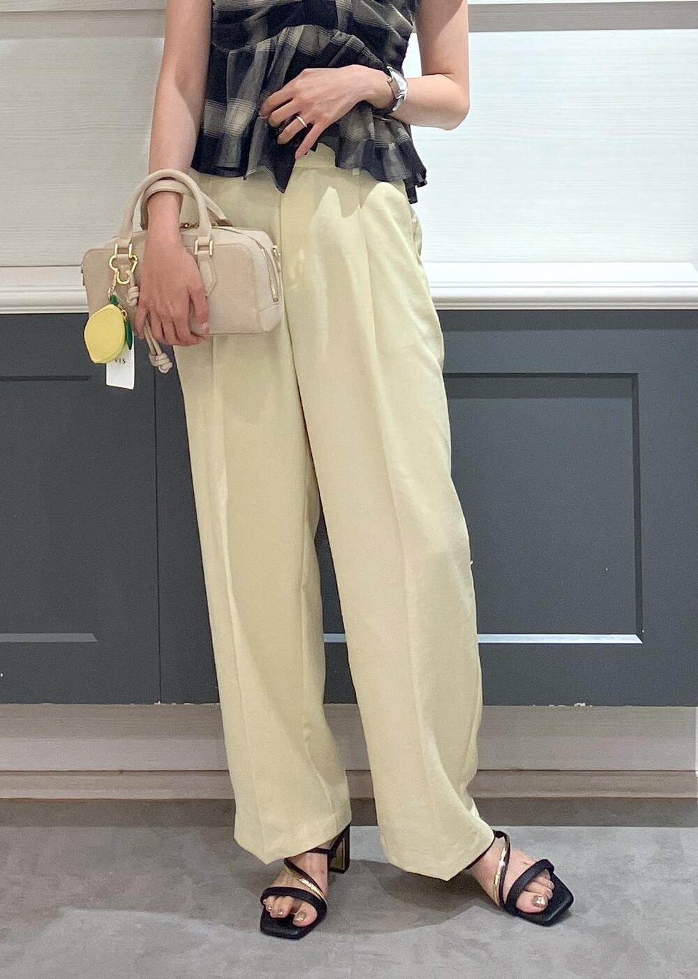 ブラック系のサンダル、イエロー系のスラックス、ブラック系のTシャツ/カットソーを着用したレディースの夏コーディネートの10枚目の写真