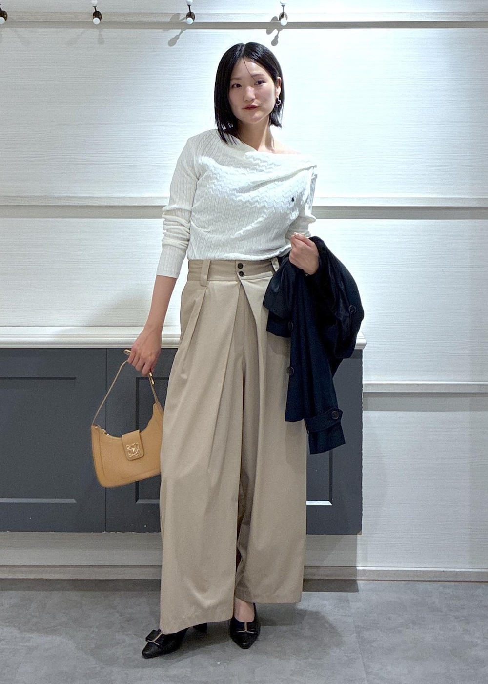 イエロー系のショルダーバッグ、ブラック系のパンプス、ブルー系のトレンチコートを着用したレディースの春コーディネートの2枚目の写真