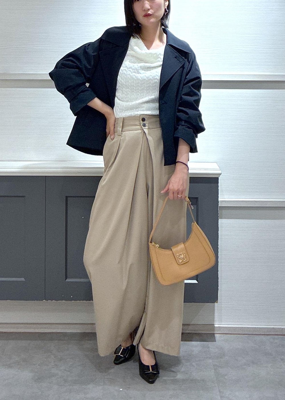 イエロー系のショルダーバッグ、ブラック系のパンプス、ブルー系のトレンチコートを着用したレディースの春コーディネートの3枚目の写真