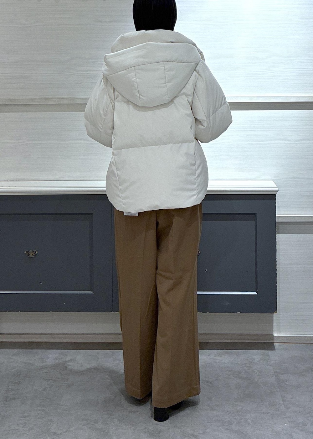 ブラック系のタンクトップ、ホワイト系のダウンジャケット/コート、ブラック系のブーツを着用したレディースの秋コーディネートの5枚目の写真