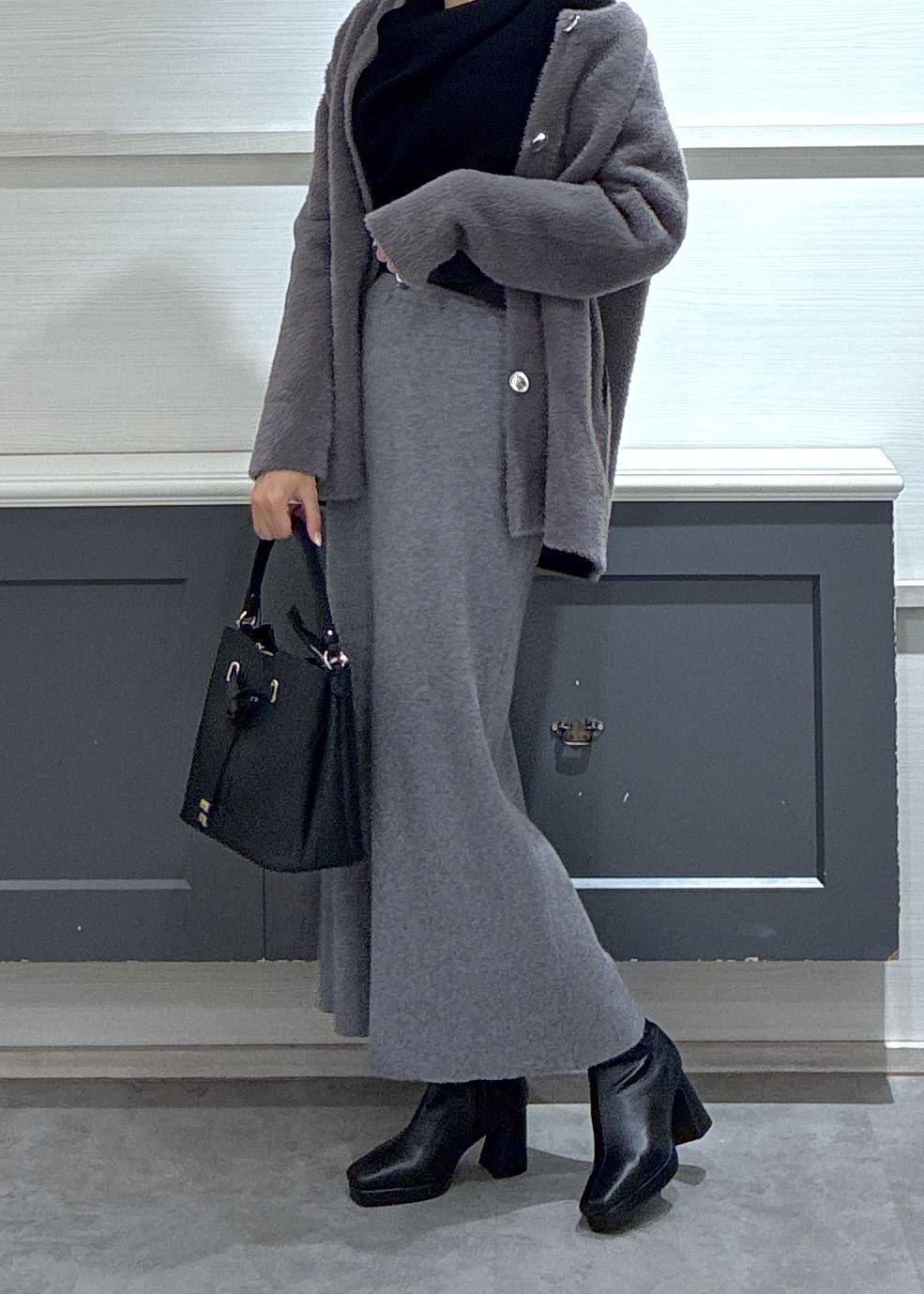 ブラック系のショルダーバッグ、ブラック系のブーツ、グレー系のスカートを着用したレディースの秋コーディネートの3枚目の写真