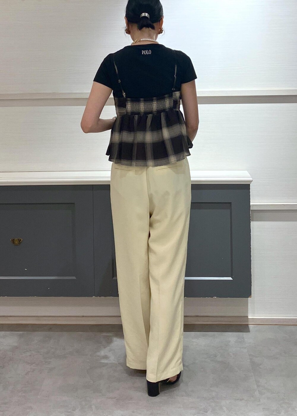 ブラック系のサンダル、イエロー系のスラックス、ブラック系のTシャツ/カットソーを着用したレディースの夏コーディネートの4枚目の写真