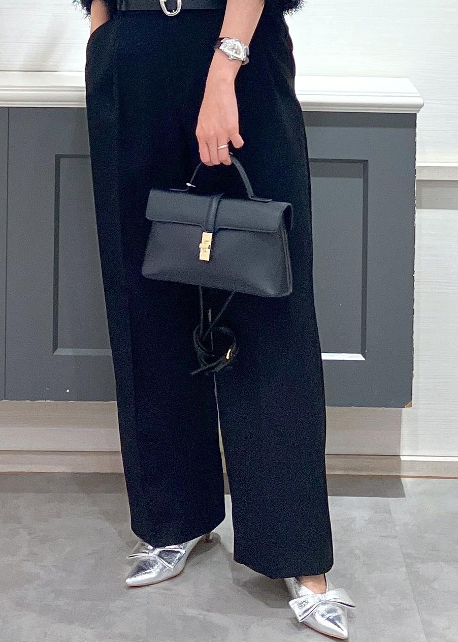 シルバー系のパンプス、ブラック系のショルダーバッグ、ブラック系のスラックスを着用したレディースの冬コーディネートの10枚目の写真