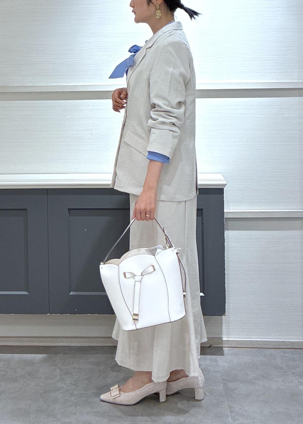 ホワイト系のショルダーバッグ、ベージュ系のパンプス、ブルー系のシャツ/ブラウスを着用したレディースの春コーディネートの8枚目の写真