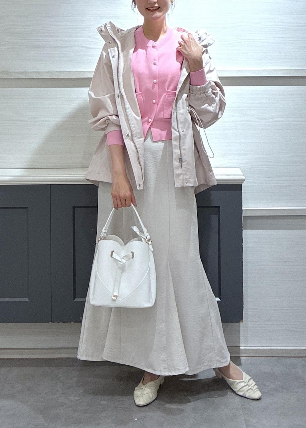 ホワイト系のショルダーバッグ、ホワイト系のパンプス、ホワイト系のスカートを着用したレディースの春コーディネートの2枚目の写真