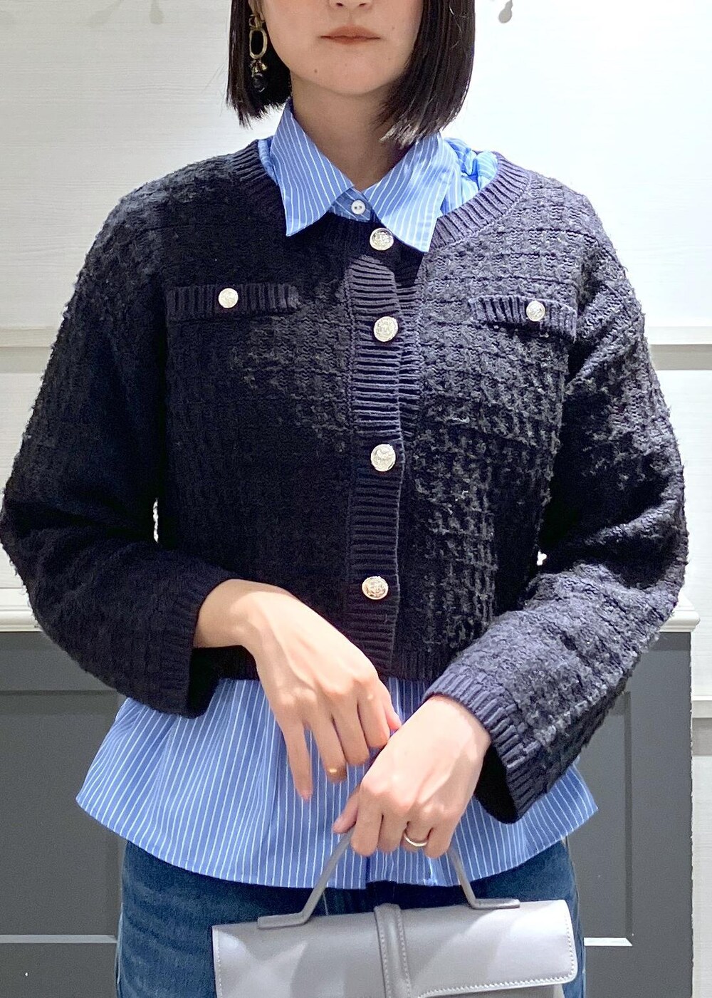 ブラック系のパンプス、グレー系のショルダーバッグ、ブルー系のシャツ/ブラウスを着用したレディースの秋コーディネートの4枚目の写真