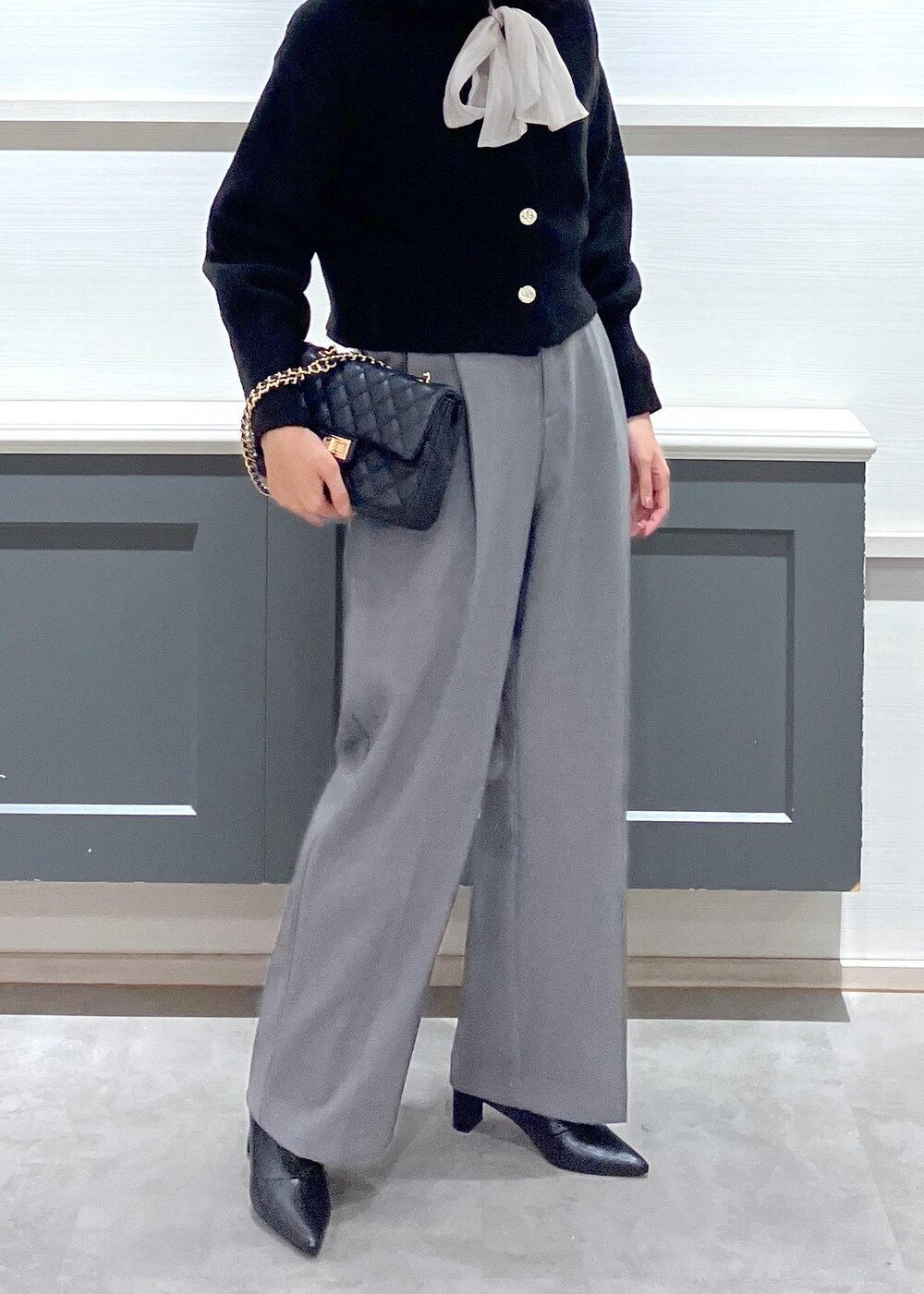 ブラック系のブーツ、ブラック系のショルダーバッグ、ベージュ系のシャツ/ブラウスを着用したレディースの秋コーディネートの2枚目の写真