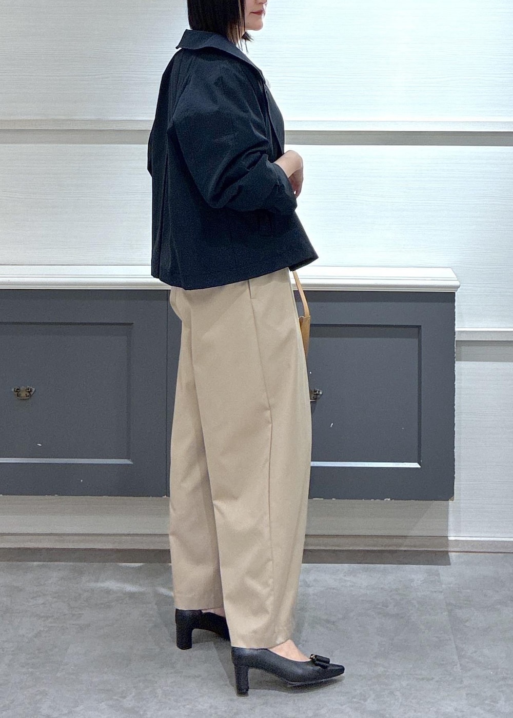 イエロー系のショルダーバッグ、ブラック系のパンプス、ブルー系のトレンチコートを着用したレディースの春コーディネートの4枚目の写真