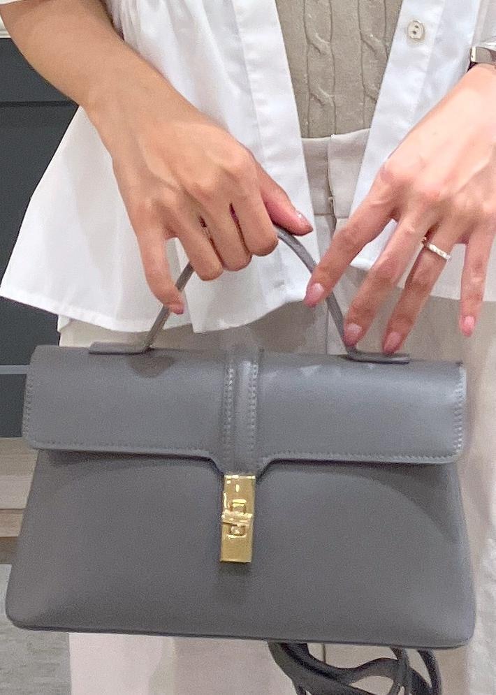 グレー系のショルダーバッグ、ブラック系のパンプス、ホワイト系のスラックスを着用したレディースの夏コーディネートの10枚目の写真