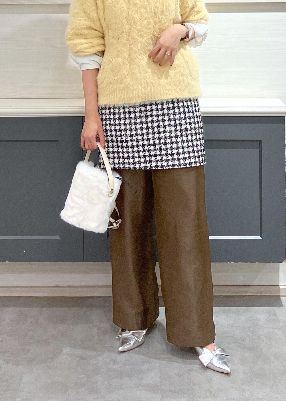 シルバー系のパンプス、ブラック系のスカート、ホワイト系のシャツ/ブラウスを着用したレディースの冬コーディネートの9枚目の写真