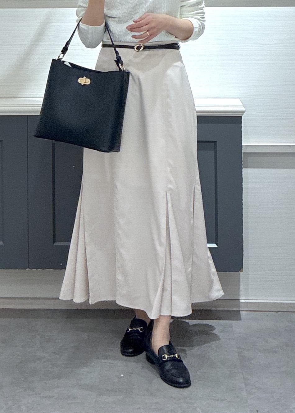 ベージュ系のテーラードジャケット、ブラック系のローファー、ベージュ系のスカートを着用したレディースの冬コーディネートの10枚目の写真