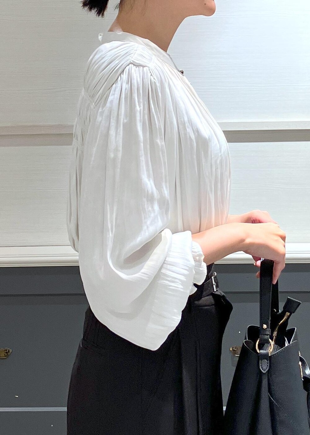 ブラック系のパンプス、ブラック系のショルダーバッグ、ブラック系のスラックスを着用したレディースの夏コーディネートの7枚目の写真