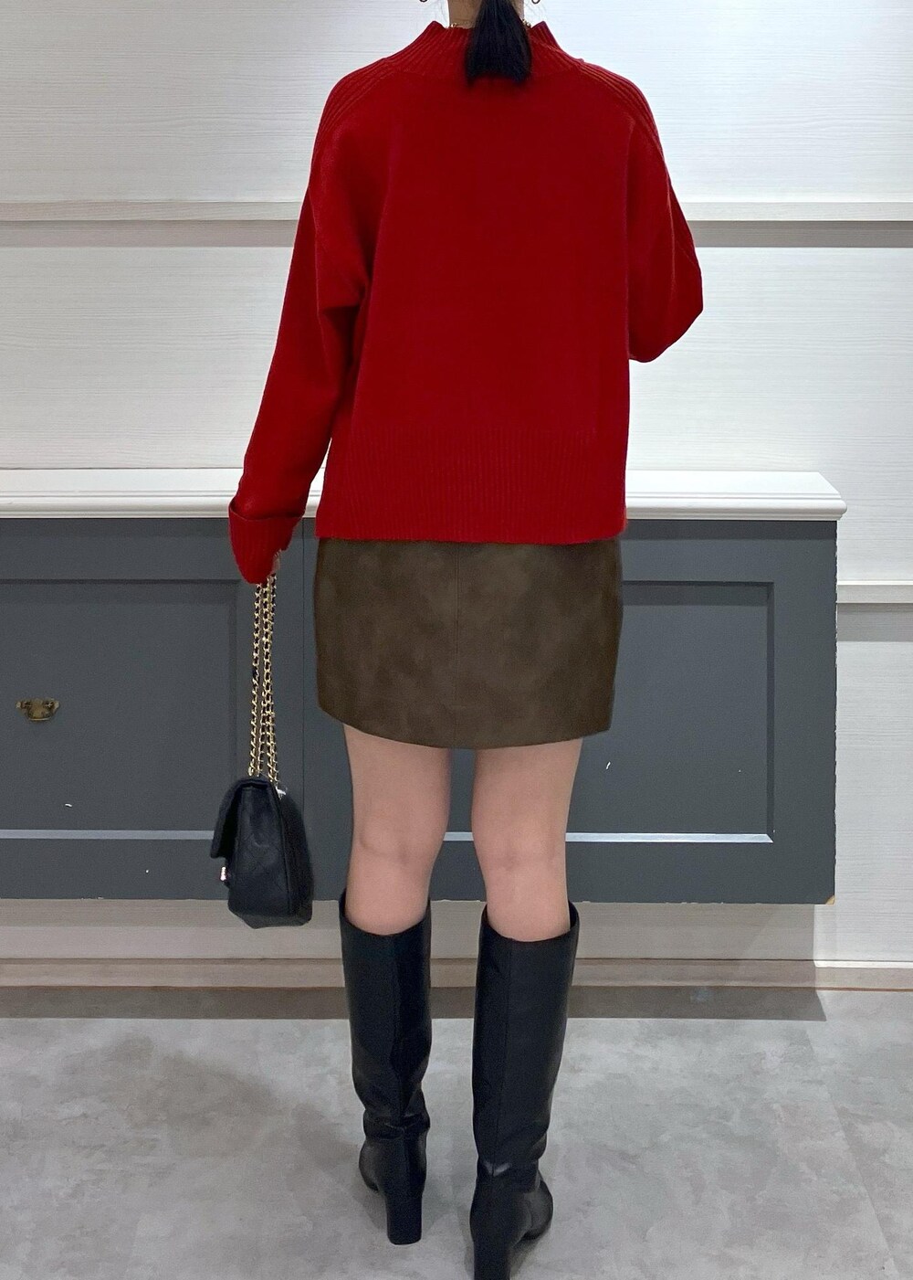 ホワイト系のキャミソール、ブラック系のブーツ、ブラック系のスカートを着用したレディースの秋コーディネートの9枚目の写真