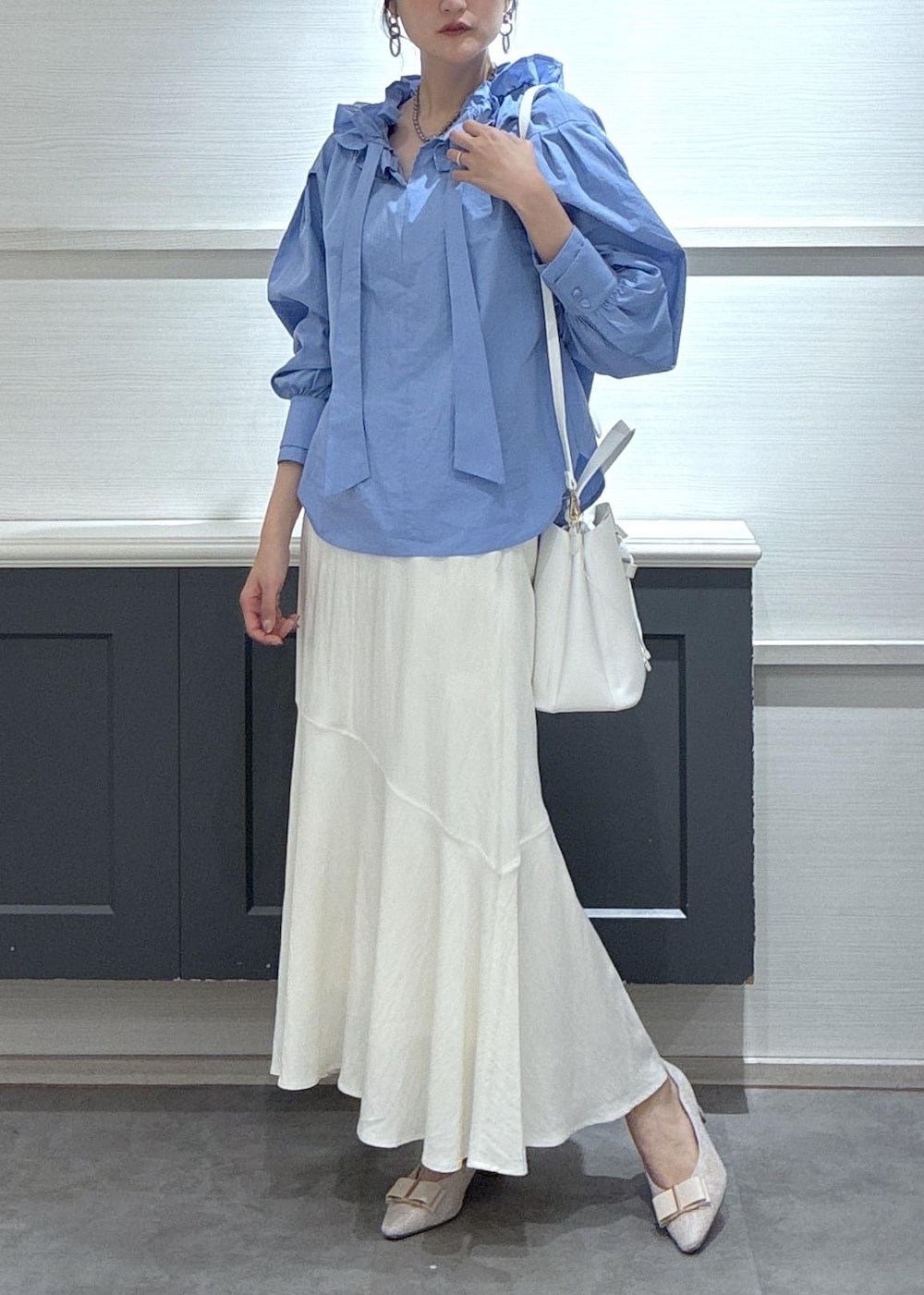 ホワイト系のショルダーバッグ、ベージュ系のパンプス、ホワイト系のキャミソールを着用したレディースの春コーディネートの2枚目の写真