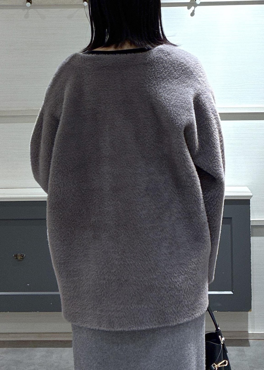 ブラック系のショルダーバッグ、ブラック系のブーツ、グレー系のスカートを着用したレディースの秋コーディネートの9枚目の写真