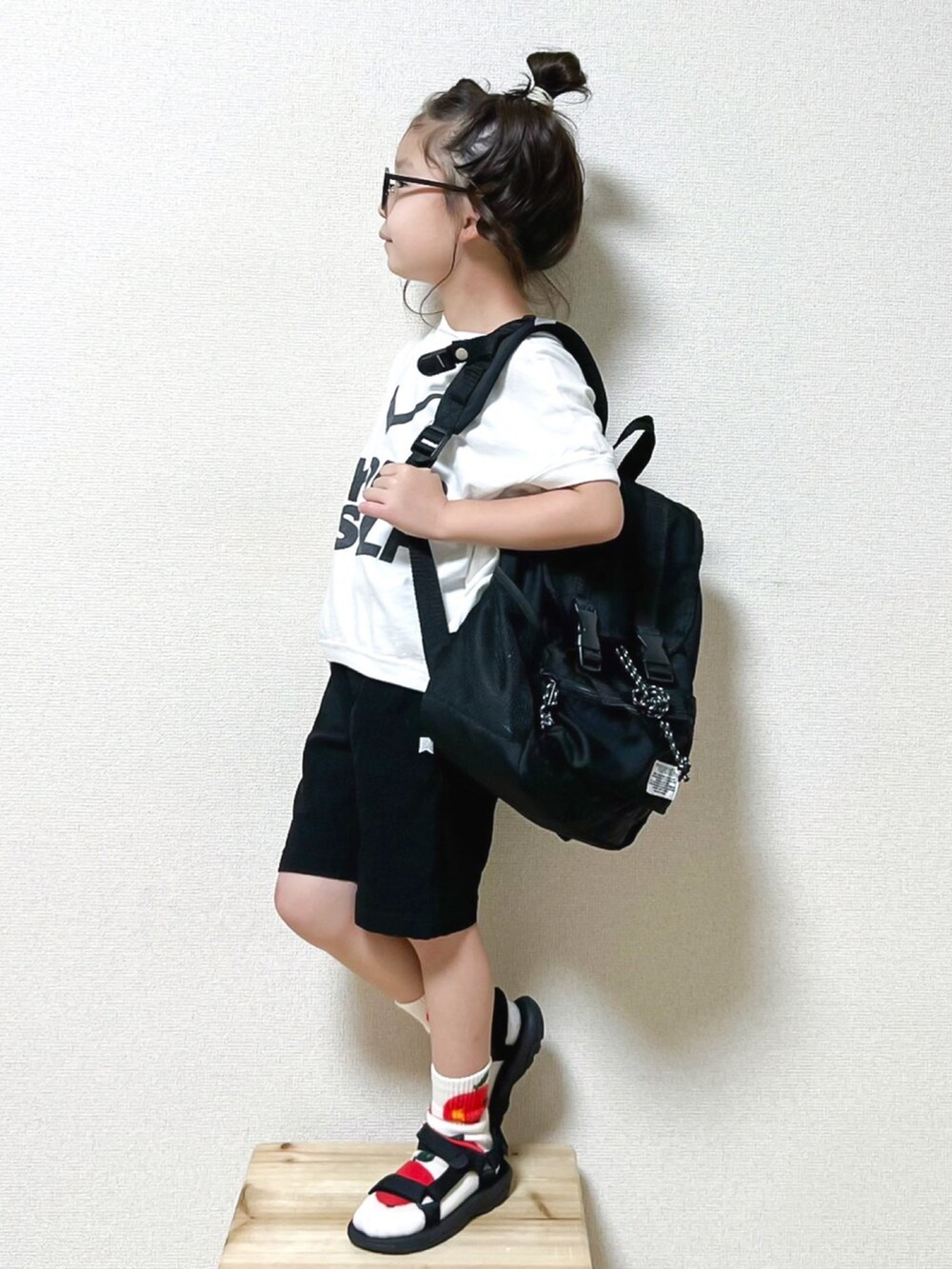 ブラック系のサンダル、ホワイト系のTシャツ/カットソー、ブラック系のボディバッグ/ウエストポーチを着用したキッズの夏コーディネートの2枚目の写真