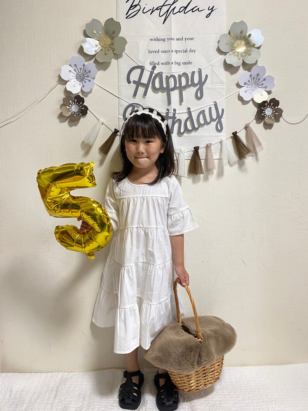 ホワイト系のワンピース、ブラック系のサンダルを着用したキッズの春コーディネートの2枚目の写真