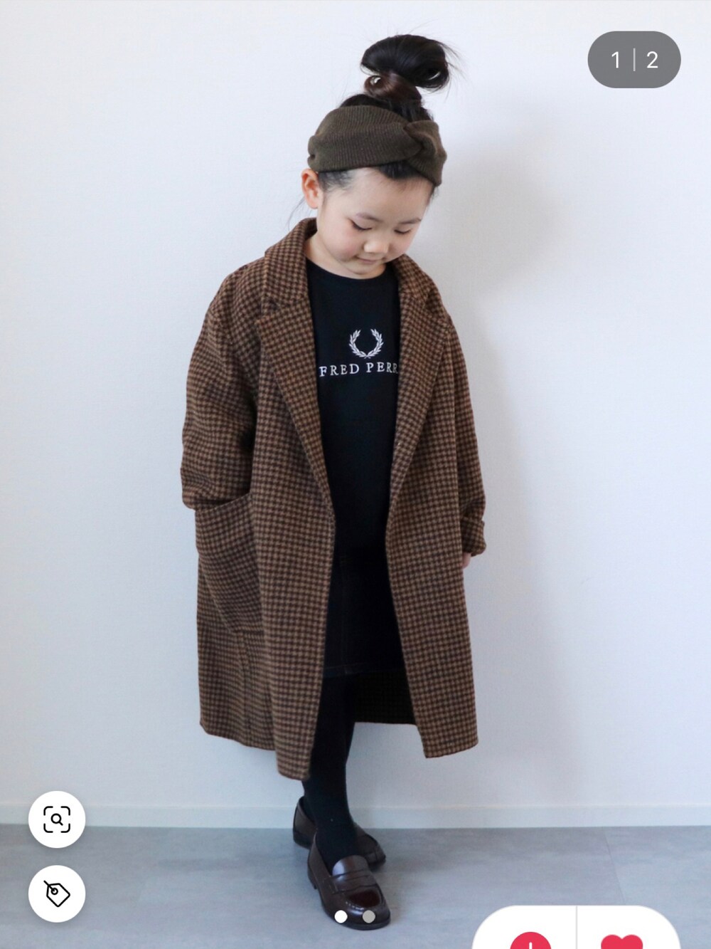 ベージュ系のチェスターコート、ブラック系のTシャツ/カットソー、ブルー系のデニムパンツを着用したキッズの冬コーディネートの2枚目の写真