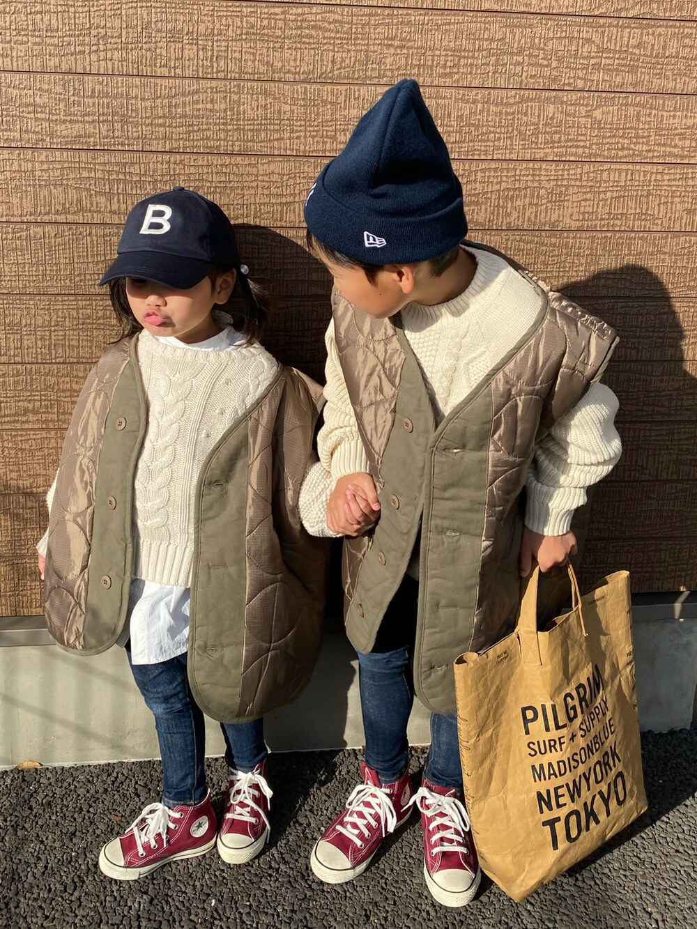 グリーン系のダウンベスト、ホワイト系のニット/セーター、ホワイト系のニット/セーターを着用したキッズの秋コーディネートの2枚目の写真