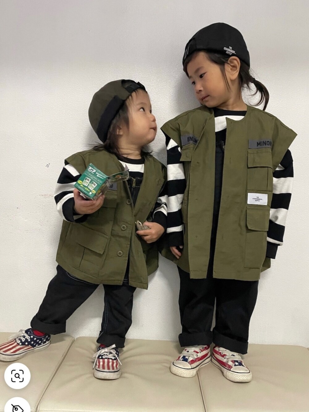 ブラック系のTシャツ/カットソー、グリーン系のダウンベスト、ブラック系のサロペット/オーバーオールを着用したキッズの春コーディネートの2枚目の写真