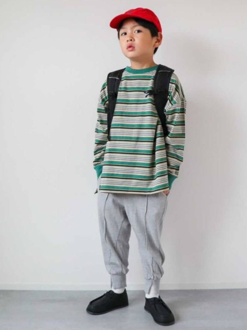 グリーン系のTシャツ/カットソー、グレー系のスウェットパンツ、ブラック系のスニーカーを着用したキッズの秋コーディネートの2枚目の写真