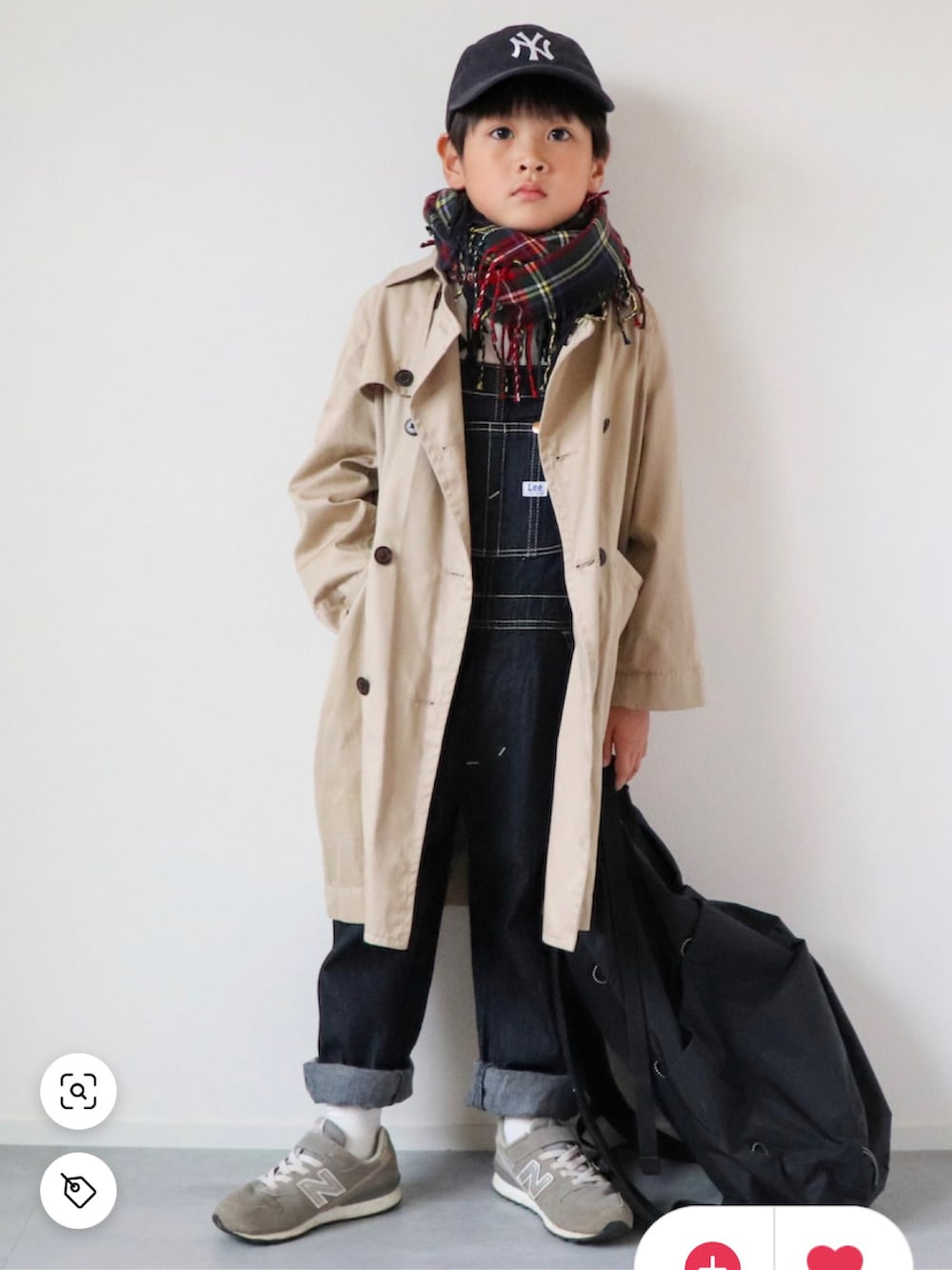 ベージュ系のトレンチコート、ブルー系のサロペット/オーバーオール、グレー系のスニーカーを着用したキッズの冬コーディネートの2枚目の写真