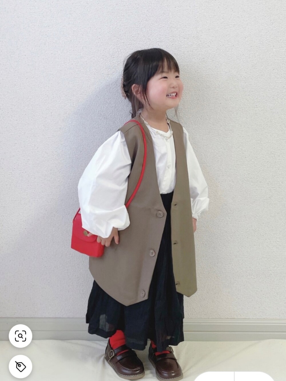 グリーン系のダウンベスト、ホワイト系のシャツ/ブラウス、ブラック系のその他パンツを着用したキッズの春コーディネートの2枚目の写真