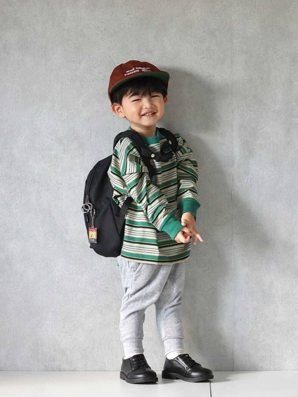 グリーン系のTシャツ/カットソー、グレー系のスウェットパンツ、ブラック系のスニーカーを着用したキッズの秋コーディネートの3枚目の写真