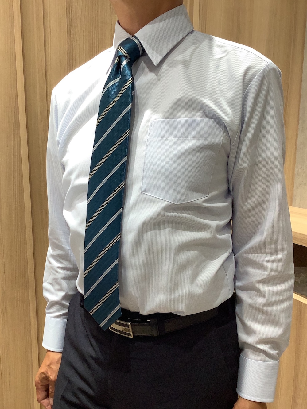 ブルー系のビジネスシャツを着用したメンズの夏コーディネートの2枚目の写真