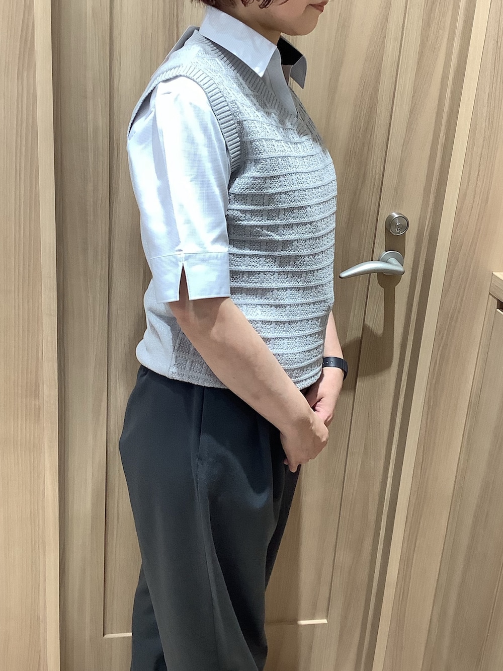 グレー系のビジネスシャツ、グレー系のベストを着用したレディースの春コーディネートの2枚目の写真