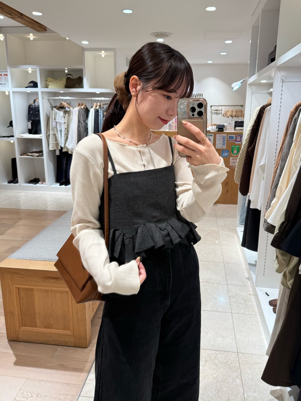 ブラック系のデニムパンツ、グレー系のシャツ/ブラウス、ホワイト系のカーディガン/ボレロを着用したレディースの秋コーディネートの2枚目の写真