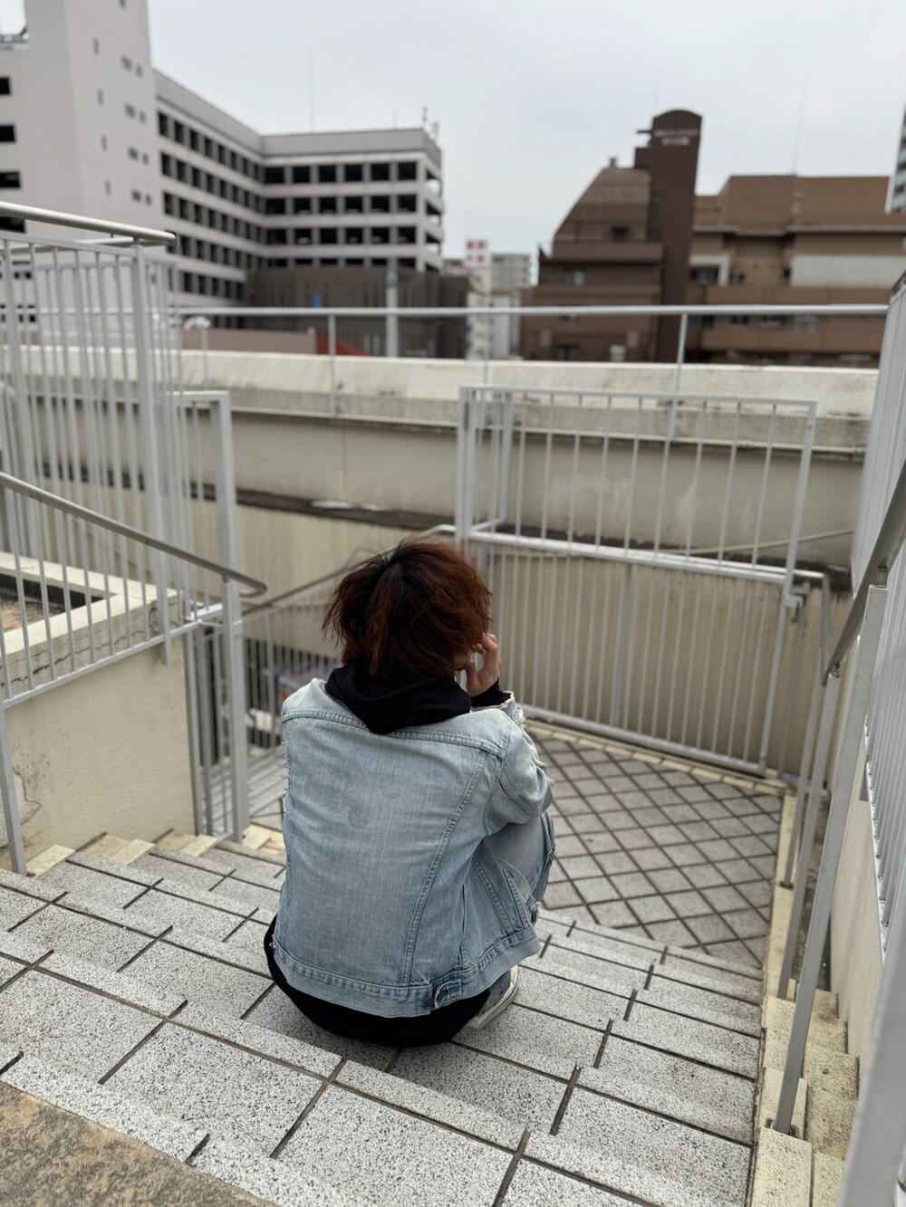 ホワイト系のスニーカー、ブルー系のデニムジャケット、ブルー系のデニムパンツを着用したメンズの春コーディネートの2枚目の写真