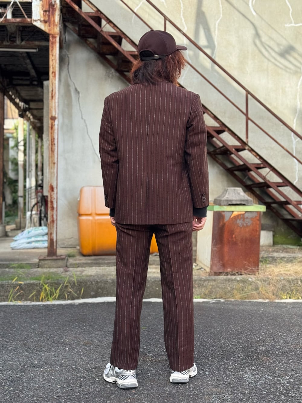 ブラック系のTシャツ/カットソー、ブラウン系のテーラードジャケット、ブラウン系のベストを着用したメンズの秋コーディネートの2枚目の写真