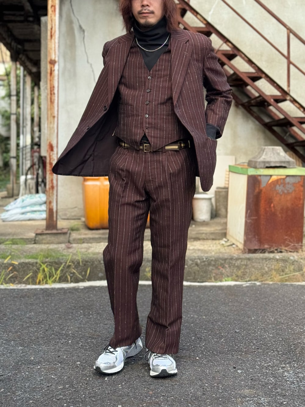 ブラック系のTシャツ/カットソー、ブラウン系のテーラードジャケット、ブラウン系のベストを着用したメンズの秋コーディネートの5枚目の写真