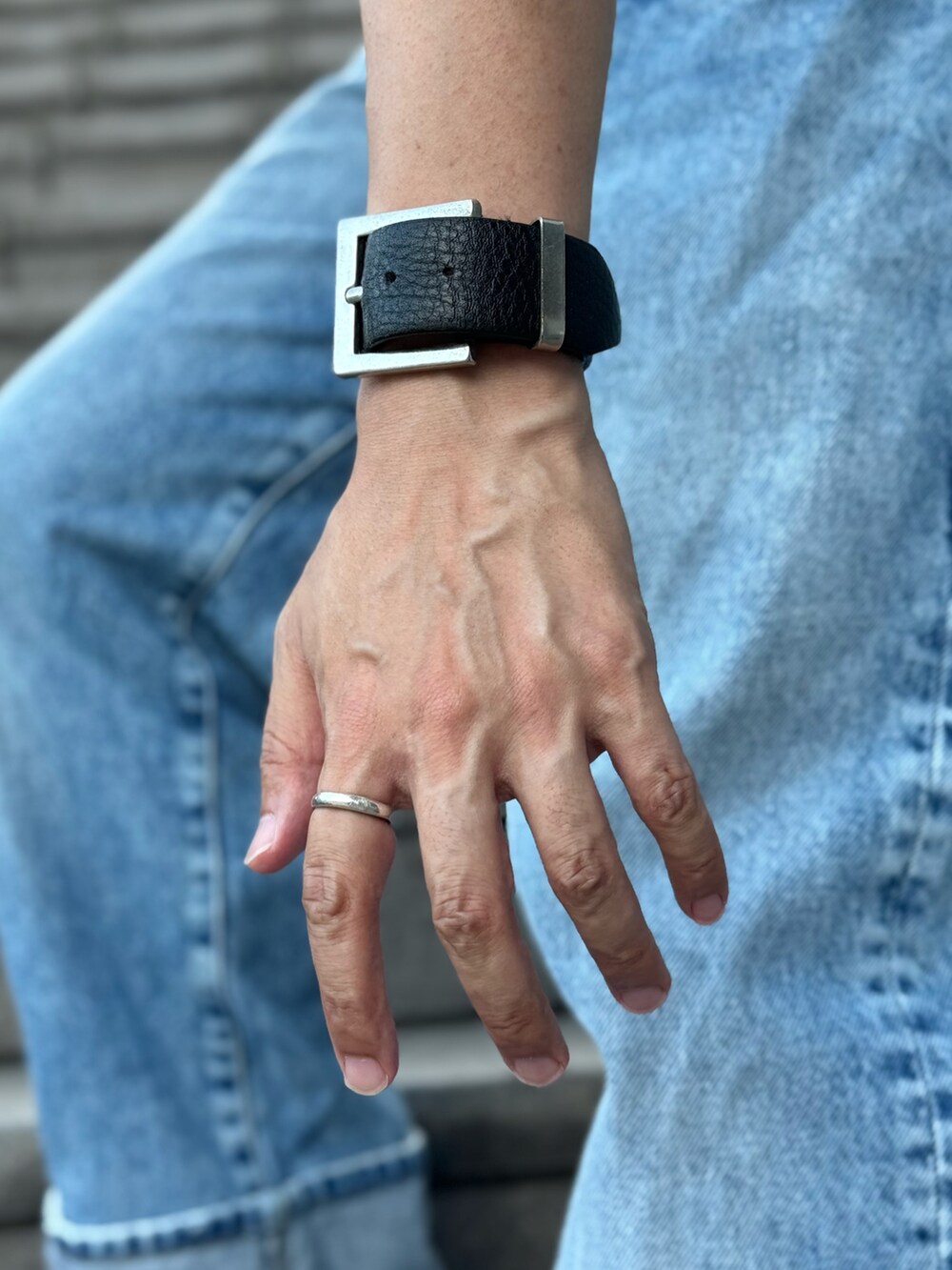 ブラック系のTシャツ/カットソー、ブラック系のブーツ、ブルー系のデニムパンツを着用したメンズの夏コーディネートの4枚目の写真