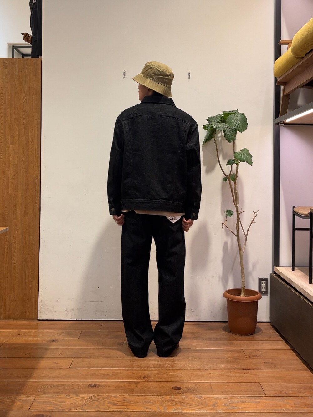 ブラック系のデニムジャケット、ベージュ系のTシャツ/カットソー、ブラック系のデニムパンツを着用したメンズの夏コーディネートの3枚目の写真