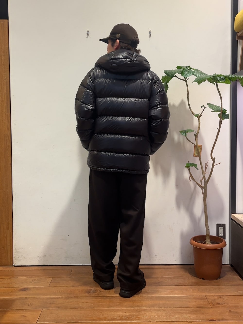 ブラウン系のその他パンツ、グリーン系のニット/セーター、ブラック系のダウンジャケット/コートを着用したメンズの秋コーディネートの3枚目の写真