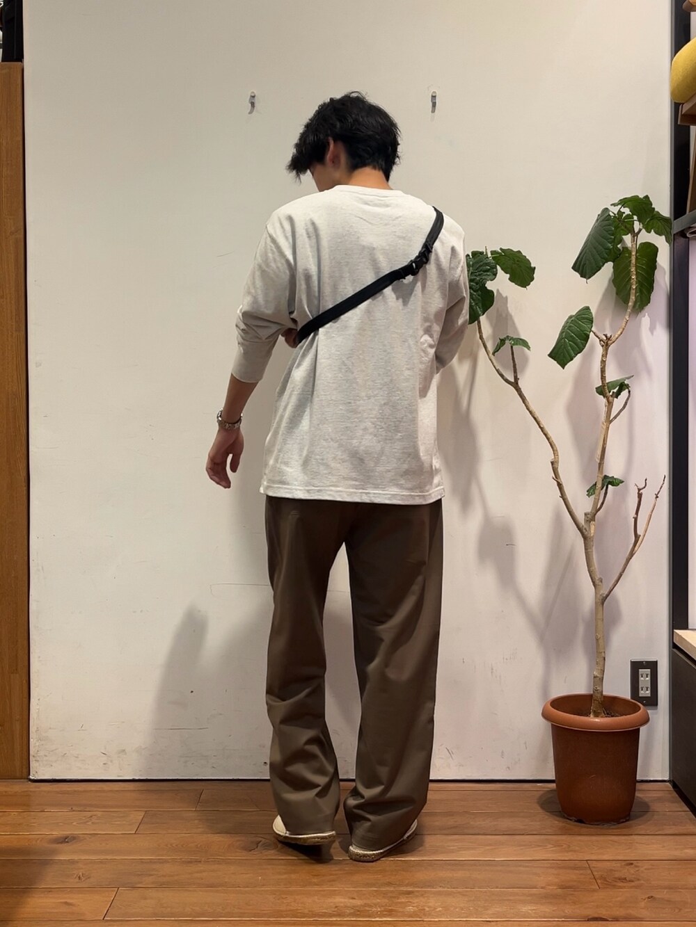 グレー系のTシャツ/カットソー、ブラック系のショルダーバッグ、ベージュ系のその他パンツを着用したメンズの秋コーディネートの3枚目の写真