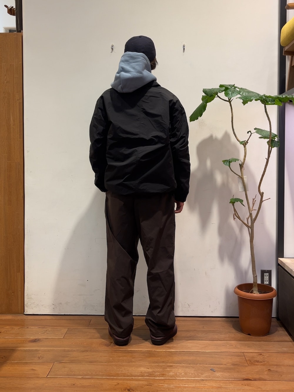 ブラウン系のその他パンツ、ブルー系のパーカー、ブラック系のナイロンジャケットを着用したメンズの冬コーディネートの3枚目の写真