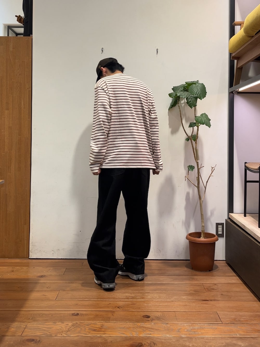レッド系のTシャツ/カットソー、ブラック系のデニムジャケット、ブラック系のスニーカーを着用したメンズの夏コーディネートの4枚目の写真
