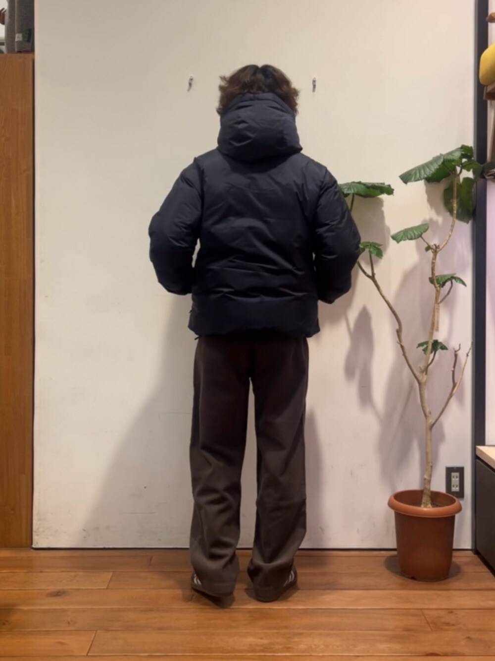 ブラウン系のニット/セーター、ブルー系のダウンジャケット/コート、ブラウン系のその他パンツを着用したメンズの冬コーディネートの3枚目の写真