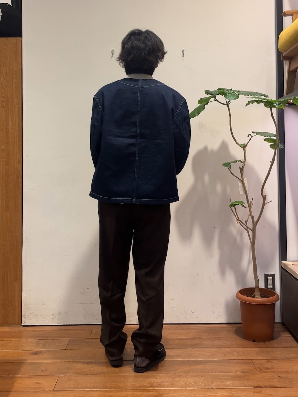 グレー系のポロシャツ、ブルー系のデニムジャケット、ブラウン系のその他パンツを着用したメンズの秋コーディネートの3枚目の写真